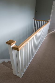 an empty room with carpeted flooring and white railing