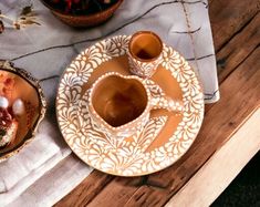 two plates with desserts on them sitting on a table next to cups and saucers