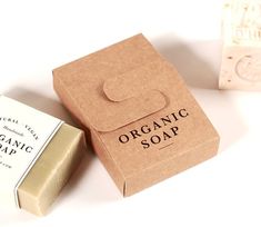 two soap bars sitting next to each other on top of a white table with an organic soap box