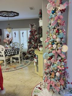 a decorated christmas tree in the middle of a living room with other decorations on it