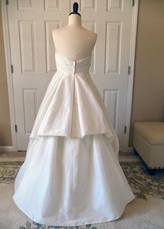 a white wedding dress on display in front of a door