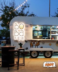 a food truck parked in front of a building with lights on it's side