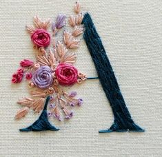 an embroidered letter with flowers on it