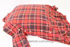 a red plaid shirt laying on top of a white surface