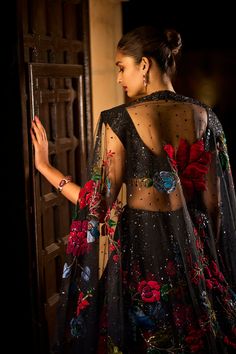 This black lehenga set features multi-coloured floral applique with delicate sequin work. The ensemble is paired with a fully embroidered sequin blouse and a matching net dupatta.From Seema Gujral’s Noori collection. DELIVERY TIMEPlease allow 4 months for your outfit to arrive. FABRIC DETAILSNet Professional cleaning only. Black Sharara With Floral Embroidery For Reception, Black Floral Embroidery Anarkali Set For Festive Occasions, Black Floral Embroidered Lehenga For Diwali, Festive Black Anarkali Set With Floral Embroidery, Black Lehenga With Floral Embroidery For Diwali, Black Sequined Sharara With Traditional Drape, Black Lehenga With Sequins In Traditional Drape, Black Lehenga With Sequins And Traditional Drape, Black Party Wear Choli With Sheer Dupatta