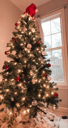 a small christmas tree with red and white ornaments