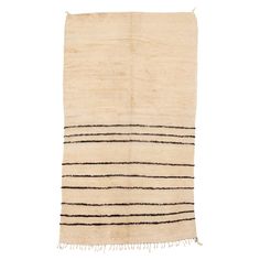 a white and black striped rug with fringes on the bottom, against a white background