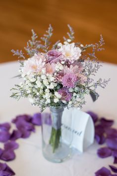 a vase filled with lots of flowers on top of a table