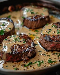 three steaks covered in gravy and garnished with parmesan cheese