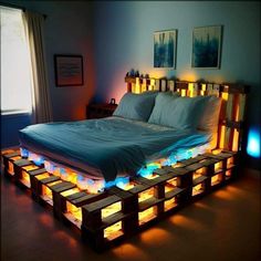 a bed made out of pallets and lit up with lights on the bottom side