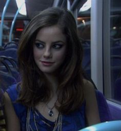 a woman sitting on a bus looking at the camera