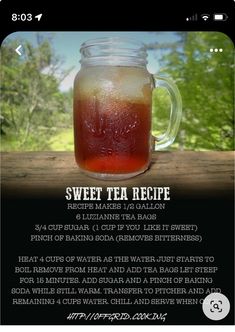 a jar filled with liquid sitting on top of a wooden table next to a forest