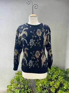 "Vintage Cristina's pullover glam sweater black knit with metallic silver gold floral Sz M. Made in Taiwan good condition. Made of nylon acrylic metallic blend.  Measurements no stretch included  Shoulders 21\" Sleeves 19\" Bust 40\" Waist 34\" Hips 30\" Length 25\""