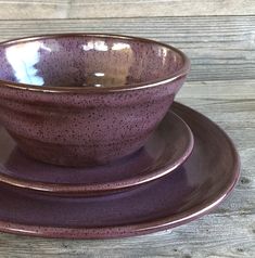 a purple cup and saucer sitting on top of a wooden table next to each other