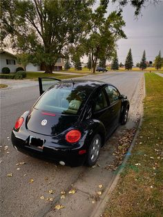 a black car is parked on the side of the road