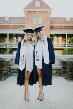 two women in graduation gowns posing for the camera