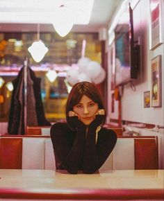 a woman sitting at a table in a restaurant