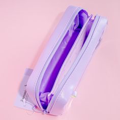 an open purple purse sitting on top of a pink surface