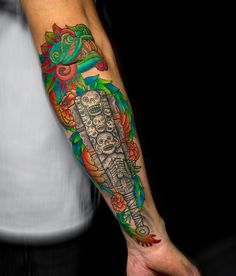 a man's arm with a colorful tattoo on it and a ship in the background