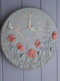 a clock with flowers and butterflies painted on it