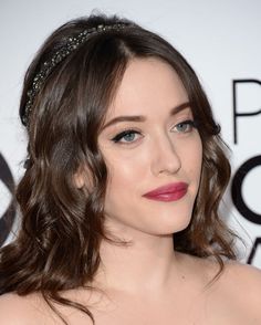 a close up of a person wearing a dress and a headband with pearls on it