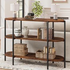 a living room with a white couch and a wooden shelf filled with books on top of it