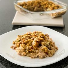 a white plate topped with food next to a casserole dish