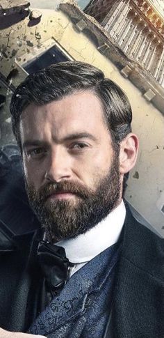 a man with a beard wearing a suit and bow tie in front of an old building