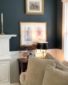 a living room filled with furniture and a fire place in front of a painting on the wall