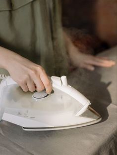 a person is ironing something with a steam iron