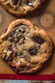 two chocolate chip cookies sitting on top of a table