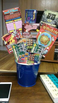 a bucket full of movie tickets sitting on top of a table next to a cell phone