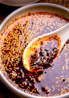 a spoon full of sauce with sesame seeds in it