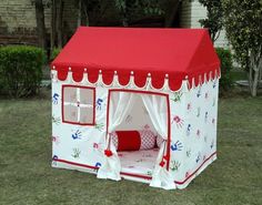 a red and white tent sitting in the grass