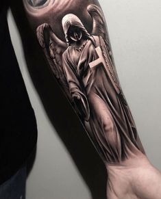 a man with a cross and angel tattoo on his arm