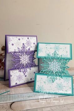 three cards with snowflakes on them sitting on a table next to some scissors