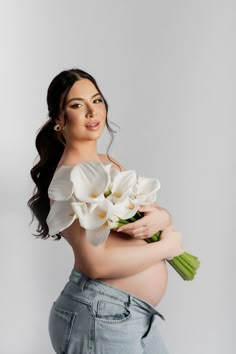 a pregnant woman holding flowers in her belly