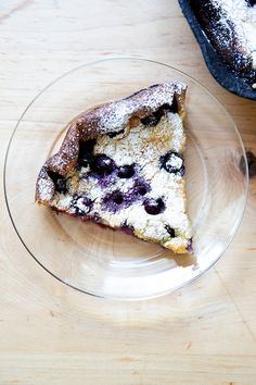 a piece of blueberry cake on a glass plate