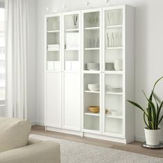 a white bookcase with glass doors in a living room