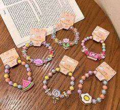 several bracelets and necklaces on a table next to an open book