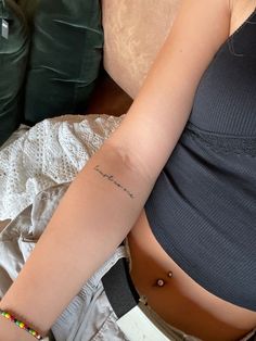 a woman with a small tattoo on her left arm and the word love is written in cursive writing