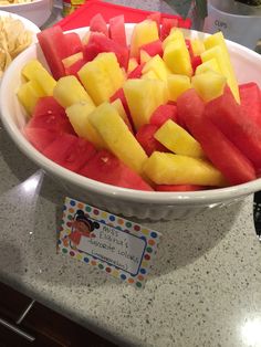 a bowl filled with cut up watermelon and pineapple slices on top of a counter