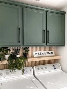 a washer and dryer in a room with green cupboards on the wall