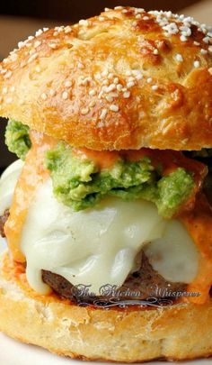 a hamburger with cheese and broccoli on it