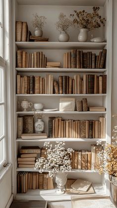 a bookshelf filled with lots of books and vases on top of it