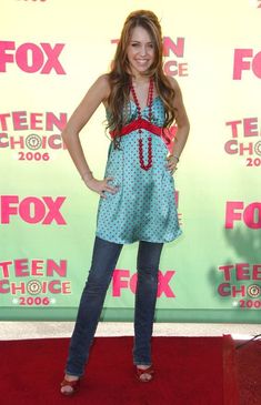 a young woman standing on a red carpet in front of a green wall with the words teen choice written on it