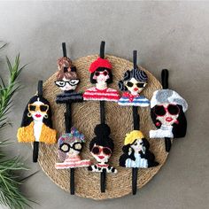 a group of knitted dolls sitting on top of a wooden table next to a plant