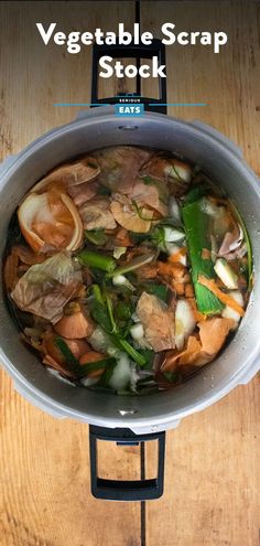 a pot filled with vegetables on top of a wooden table