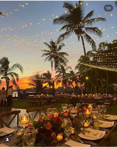 an outdoor dining area with tables and chairs set up for dinner under string lights at sunset