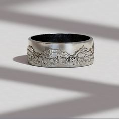 a silver ring with mountains in the background